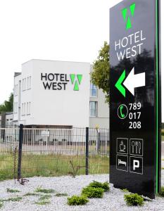 波兹南Poznań West Hotel - Airport的建筑前的酒店标志前的标志