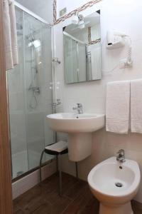 米兰皮奥拉酒店的白色的浴室设有水槽和淋浴。
