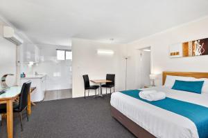 亚斯亚斯雷鸟汽车旅馆的酒店客房带一张床、一张桌子和椅子