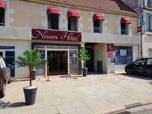 讷韦尔Nevers Hotel的前面设有汽车停车场的酒店大楼