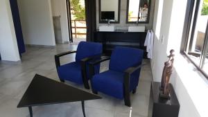 豪特湾梦想酒店的客厅配有2把蓝色椅子和桌子