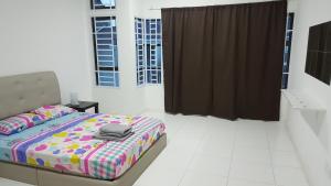 巴西古当F.A Guesthouse Pasir Gudang的一间卧室配有一张带彩色毯子的床
