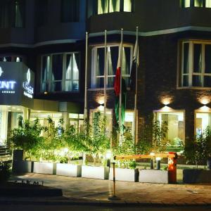 科威特勒金特公寓式酒店的一座在晚上有长凳的建筑