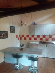 科姆梅扎杜拉马索德尔卡皮特尔公寓的厨房配有柜台和2个酒吧凳