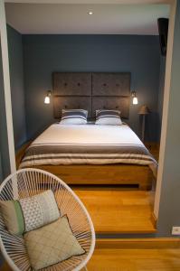 斯帕La Suite Des Pervenches的一间卧室配有一张大床和一把椅子