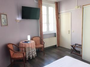布兰肯贝赫克拉里奇酒店的客房设有桌子、两把椅子和窗户。