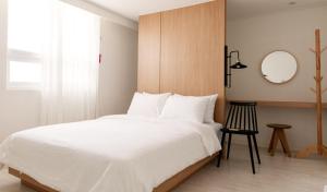 釜山Hotel Kyungsung的卧室配有一张白色大床和镜子