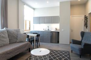 文茨皮尔斯A9A（织工9公寓）公寓的带沙发和桌子的客厅以及厨房。