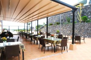 洛西洛斯卢斯德尔马酒店的一间带桌椅和石墙的餐厅