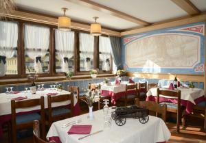 帕苏德尔托纳莱布丽赛娜酒店的用餐室设有桌椅和窗户。