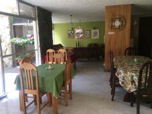 危地马拉Hostal Los Lagos Inn的一间带绿色桌椅的用餐室