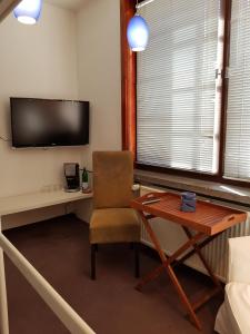 鲁多尔施塔特Casa Conne的客房设有书桌、椅子和电视。