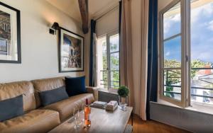 巴黎Luxurious Duplex - Top of Montmartre的带沙发、桌子和窗户的客厅