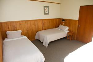 Mount SomersStronechrubie Accommodation and Restaurant的木墙客房的两张床