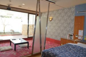 鸟栖市Hotel Silk no Mori (Adult Only)的酒店客房配有一张床铺和一张桌子。