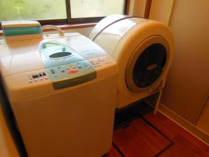 NiimiJapanese Style Inn Dohzen Miwa的窗户间里的洗衣机和烘干机