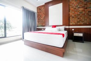 棉兰RedDoorz Plus near Kualanamu Airport的一间卧室设有一张床和砖墙