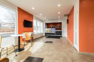 斯克内克塔迪Motel 6-Schenectady, NY的一间办公室,拥有橙色的墙壁和桌椅