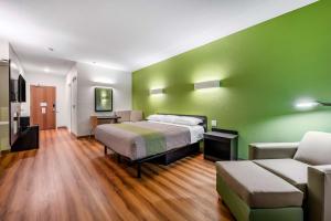 曼凯托Motel 6-Mankato, MN的一间卧室设有一张床和绿色的墙壁