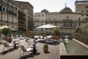 巴塞罗那ICON Bcn的一座带椅子的庭院和一座位于大楼前的游泳池
