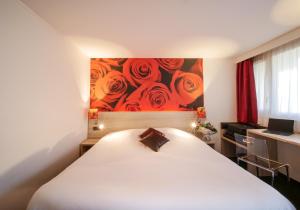 萨尔特河畔萨布雷瑞斯托诺沃撒布莱设计酒店的一间卧室配有一张白色的床,上面有玫瑰画