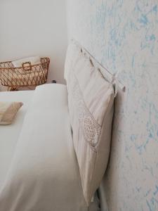 里帕特兰索内Il Vicolo di Ripa B&b的一张白色的床,墙上有枕头