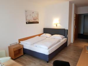 斯图加特Arthotel ANA Neotel的一间卧室配有一张带白色床单的大床