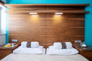 布尔诺内姆阿尔什时尚餐饮酒店的一间卧室配有木制床头板和两个枕头