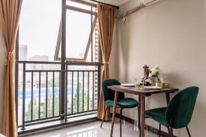 武汉武汉市洪山区·光谷步行街·路客精品公寓·00157650的一间带桌椅和大窗户的用餐室