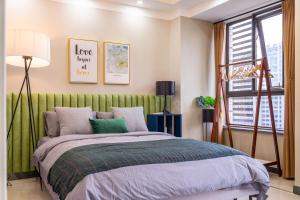 武汉武汉市洪山区·光谷步行街·路客精品公寓·00157650的一间卧室配有一张带绿色床头板的床