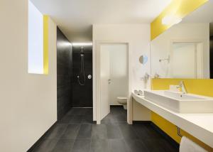 罗登戈Hotel Tirolerhof的一间带水槽和淋浴的浴室