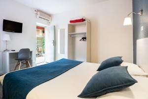 里昂莫兰德露台酒店的一间卧室配有一张带蓝色床单和枕头的床。