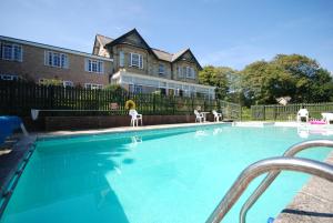 尚克林卢康蓓庄园乡间别墅酒店的房屋前的带白色椅子的游泳池