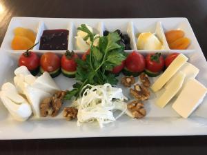 锡德亚乌兹翰酒店的一种白色的盘子,上面有不同种类的奶酪和蔬菜