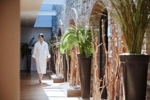 卡文Farnham Estate Spa and Golf Resort的走下走廊的女人,种着盆栽植物