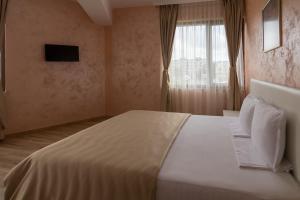 克尔贾利卡尔蒂亚丽酒店的卧室配有一张大白色床和窗户