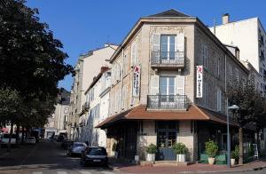 里摩日Hôtel Bistrot Le Marceau的城市街道拐角处的建筑物