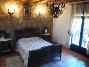 巴伦西亚德亚尔坎塔拉Hotel Rural El Convento的一间卧室设有一张床和石墙