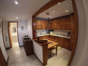 托雷拉Verde Ria apartamento的厨房配有木制橱柜和镜子内的桌子