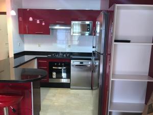 拉巴特Le nid du centre ville的厨房配有红色橱柜和不锈钢冰箱