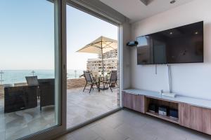多列毛利诺斯美景海滨简易别墅公寓的客厅设有滑动玻璃门,享有海景