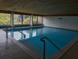 VuonislahtiHotelli Pielinen的一座大型游泳池,位于一座带窗户的建筑内