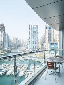 迪拜Spa招牌酒店公寓 的阳台配有桌子,享有海港景色