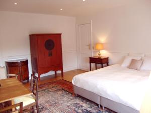 布鲁塞尔Louise Chatelain suites的一间卧室配有一张床、梳妆台和桌子