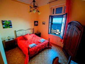 萨莱诺巴罗恩住所加早餐酒店的一间卧室设有红色的床和窗户。