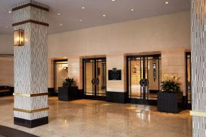 洛杉矶比佛利山庄伦敦西好莱坞酒店的大堂设有玻璃门和盆栽植物