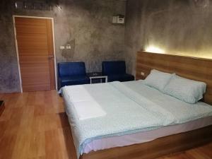 Samut SakhonSands Place Apartment and Hotel的一间卧室配有一张床和两张蓝色椅子