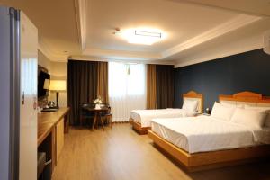 光州Gwangju Empire Hotel的酒店客房配有两张床和一张书桌