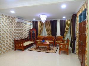 巴佐RizQin Homestay Bachok的客厅配有沙发、椅子和桌子