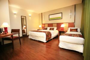 罗萨里奥1412精品酒店 的酒店客房配有两张床和一张书桌